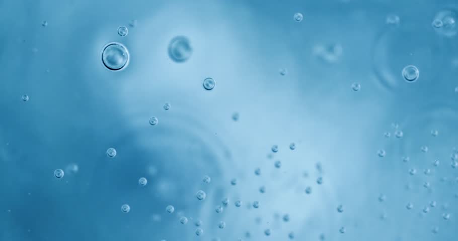 Oxygen bubbles in water on a blue abstract background on super slow motion.