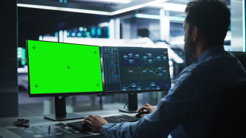 Professional Male IT Technical Support Specialist and Software Developer Working on Computer with Green Screen Mock-display in Monitoring Control Room. Programmer Fixing Hiccups in Service | Shutterstock HD Video #1111379567