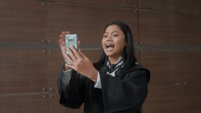 Asian Indonesian Girl Wearing Graduation Gown Video Calling, Waving Hands, Smile, Proud
