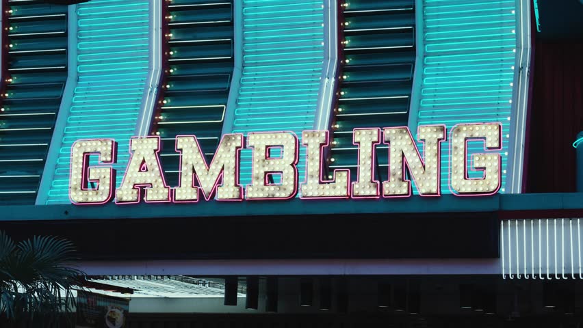 Neon lights sparkle in gold, pink, and blue to light up a gambling sign in the Fremont old town district of Las Vegas