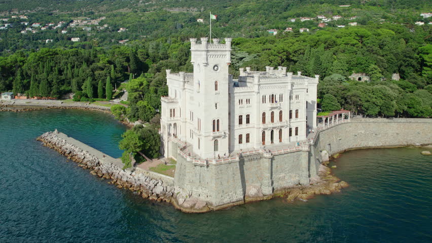 Aerial view of the Miramare Castle at the Adriatic sea coast in Italy. Drone revealing footage of the Miramare castle near Trieste, Italy. Italian summer holidays travel destination