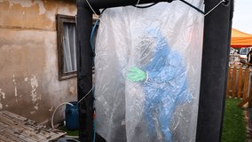 Person wears blue Personal protective equipment (PPE) with gas mask for protection from air pollution and biohazard. - Powered by Shutterstock - Get 15% off with code: PIKWIZARD15