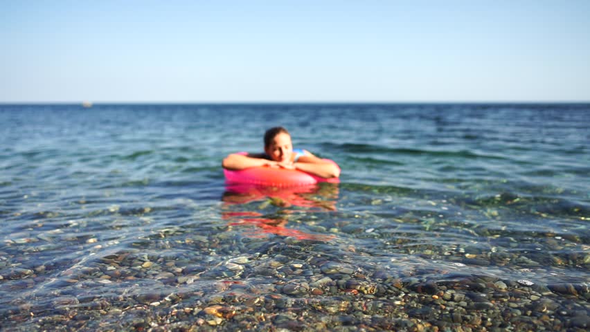 Summer vacation happy woman floats on an inflatable donut mattress, pink swim ring. Summer travel holidays vacation on the sea. Royalty-Free Stock Footage #1111391735