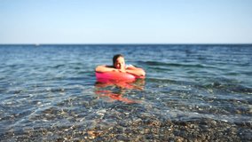 Summer vacation happy woman floats on an inflatable donut mattress, pink swim ring. Summer travel holidays vacation on the sea. - Powered by Shutterstock - Get 15% off with code: PIKWIZARD15