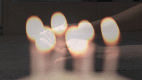 Composite video of candles blowing off over woman hands with rosary praying against people walking. Christianity and religion concept
