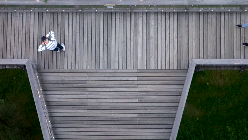 People walking on the wooden bridge under the observation tower