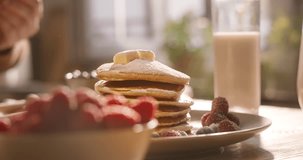 Unknown chef with refined taste aesthetically decorates elegant perfect stack of pancakes with sprig of mint herbs. Advertising cinematic. Delight in cozy morning scrumptious gluten-free breakfast