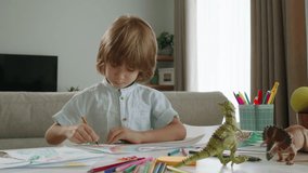 Child draws rainbow with pencil in while sitting at table. Happy family concept. Rainbow drawing isolated. Concept of place of happiness, smiles of children's creativity and happiness, development
