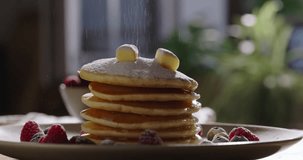 Stack of tantalizing pancakes generously sprinkled with powdered sugar. No people, advertisement. Leisurely cozy morning, essence of lifestyle, cooking, and domestic life. Culinary blog social media
