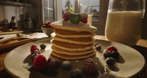 Side view of pancakes adorned with juicy berries, syrup, and sugar powder, kitchen. Advertising, no people, cinematic. Art of healthy tasty food, gluten-free recipes and delectable gluten-free options