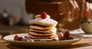 Grace and refined taste decoration of stack of pancakes with sprig of mint. Advertising cinematic. Guilt-free in tasty cheat meal, perfect balance between flavor and wellness goals. Healthy lifestyle