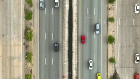 An intercity motorway, resembling a moving river of vehicles, seen from a bird's eye view courtesy of a hovering drone. Aerial view reveals road congestion. Vehicle and road concept.
