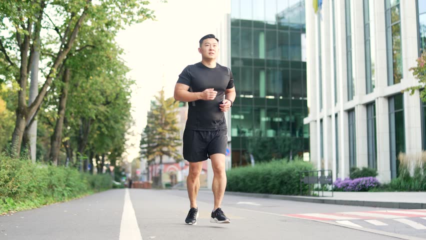 Asian runner athlete with muscle pain in city street. Man massaging stretching, trauma injury while jogging outdoors in park. Fitness male sprain severe pain stretch pull. Leg muscle cramp calf sport Royalty-Free Stock Footage #1111413925