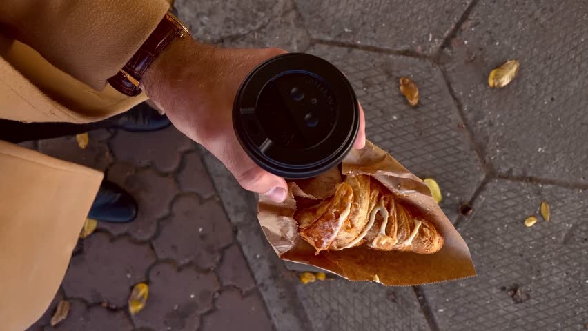 POV, male hand carry a takeaway coffee with croissant at the autumn day Royalty-Free Stock Footage #1111418829