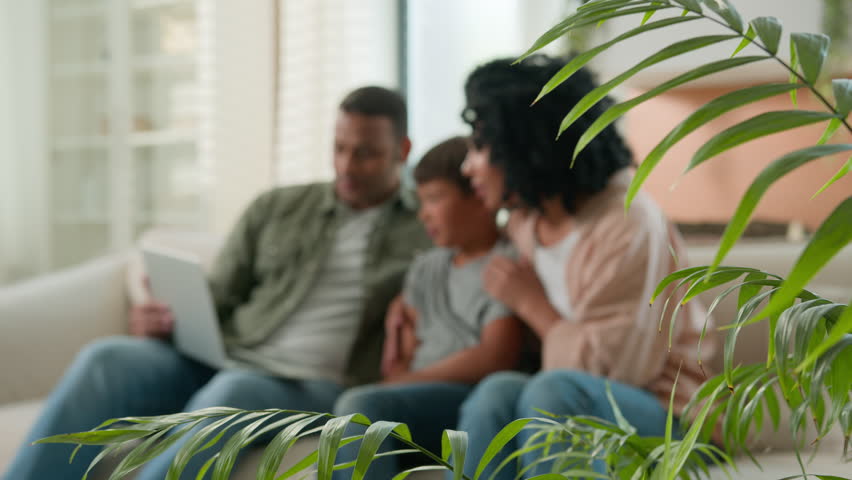 Happy multiracial family parents child kid using laptop computer on home couch excited African American mom dad Caucasian adopted little son boy celebrate achievement victory success winning at home