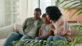 Happy multiracial family parents child kid using laptop computer on home couch excited African American mom dad Caucasian adopted little son boy celebrate achievement victory success winning at home - Powered by Shutterstock - Get 15% off with code: PIKWIZARD15