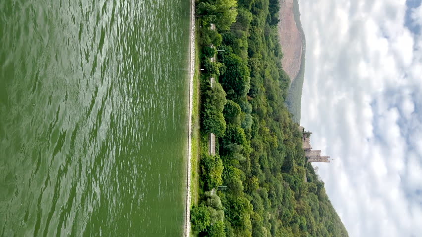 Traveling along the Rhine River with scenic views of the quaint village of Niederheimbach, Germany. Views of mountains and rolling hills with agricultural fields. 