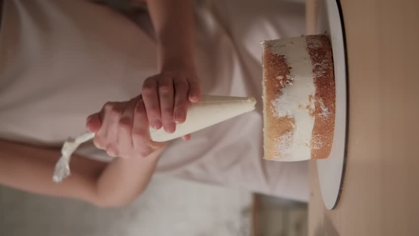 Confectioner applies the cream layer between the biscuits. Woman is cooking homemade cake. Cooking, baking and cooking, home cooking. | Shutterstock HD Video #1111422807
