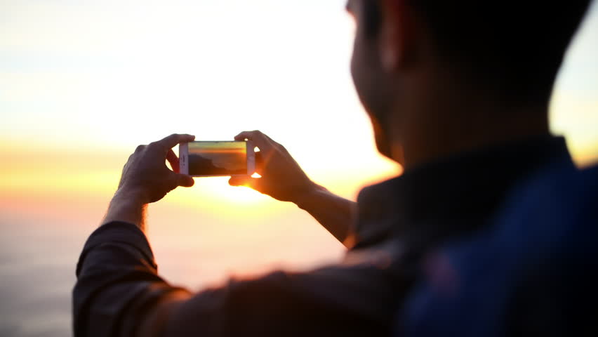 Photography, outdoor and man with a camera, nature and travel with memory, lens flare and vacation. Calm, professional and photographer taking pictures of the environment, sunshine and summer holiday