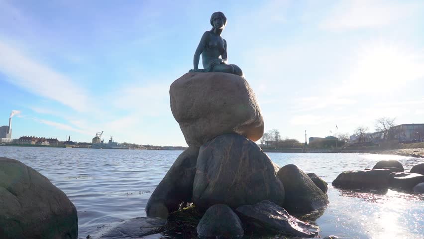 Copenhagen, Denmark - November 18, 2023: Little Mermaid Statue (Den lille Havfrue) on a rock by the waterside at the Langelinie promenade