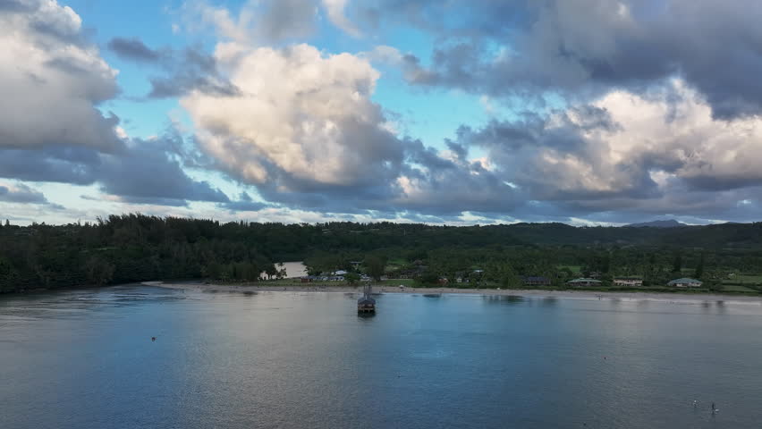 Aerial Hanalei Pier bay beach sunset Kauai Hawaii forward. Surfing and swimming ocean recreation. Bay cove for swimming, snorkel and surfing from sandy beach and boat pier. Garden Isle. Economy.