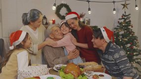 Asian kid hugging grandparent while celebrate Christmas party in house. Attractive family spending leisure free time on holiday vacation to celebrate Thanksgiving, X-mas eve on dining table at home. - Powered by Shutterstock - Get 15% off with code: PIKWIZARD15