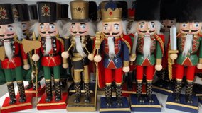 Nutcracker toys are arranged on a store shelf alongside Christmas tree ornaments and festive decorations. a lineup of Nutcracker Soldiers in uniform  - Powered by Shutterstock - Get 15% off with code: PIKWIZARD15