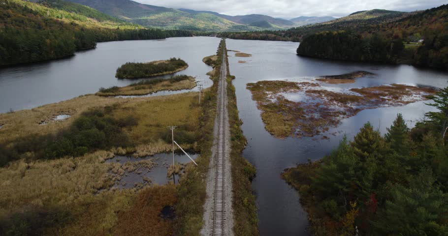 Train Railroad Surrounded River And Mountain Landscape, Aerial Shot