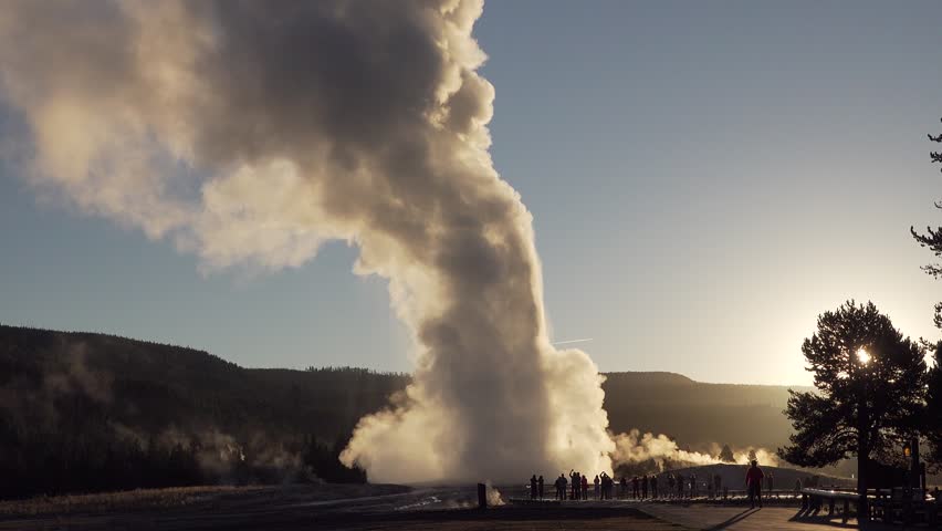 Old Faithful Geyser starts to erupt at sunrise, Yellowstone National Park, Wyoming, USA
