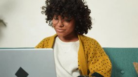 African American girl using laptop at home office looking at screen typing chatting reading writing email. Young woman having virtual meeting online chat video call conference. Work learning from home