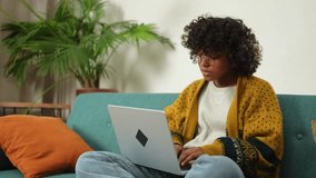 African American girl using laptop at home office looking at screen typing chatting reading writing email. Young woman having virtual meeting online chat video call conference. Work learning from home