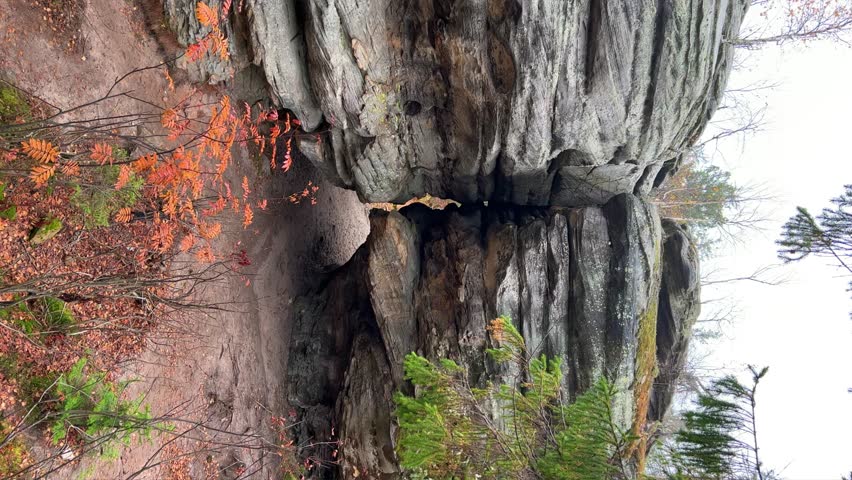 Stone City in autumn. Bright foliage and autumn landscape. The natural landscape is a rock formation in Central Russia, the Urals. A natural monument. Ancient rocky folding in the Ural Mountains. 4K