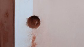 A man drills a hole in a brick wall using a hammer drill and a long concrete drill. Home repairs. Video with sound.