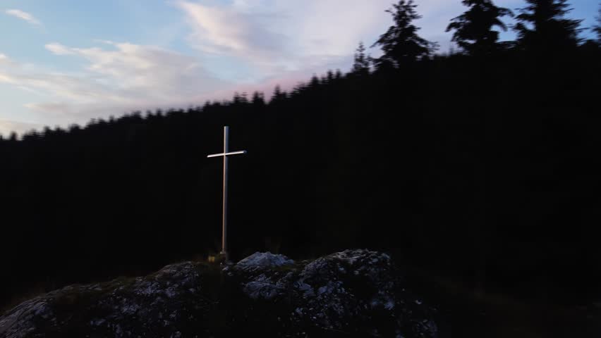 Aerial view of a religious Christian steel cross on a hill in the mountainous countryside, in sunset | Shutterstock HD Video #1111451737