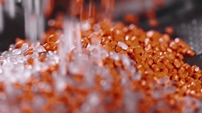 Macro frame of white and orange plastic granules. The polymer composite is poured into a tank for further production and casting in special molds. Production - Powered by Shutterstock - Get 15% off with code: PIKWIZARD15