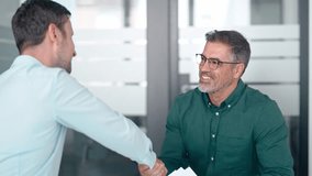 Happy business men executive partners making agreement with handshake at meeting. Company investor shaking hand of customer, client making deal in office. Getting hired at job interview concept. - Powered by Shutterstock - Get 15% off with code: PIKWIZARD15