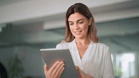 Mid aged busy businesswoman using digital tablet working in office. Middle aged professional business woman company manager standing in office working on corporate tab tech device. - Powered by Shutterstock - Get 15% off with code: PIKWIZARD15