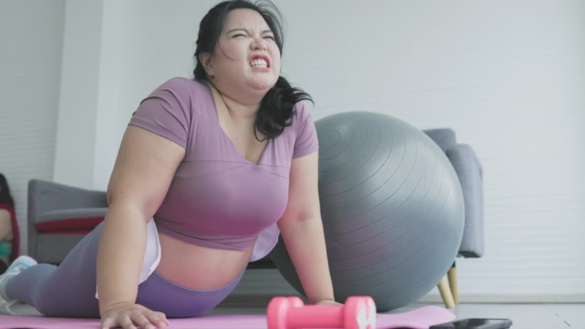 Asian chubby woman doing exercise push-ups at home | Shutterstock HD Video #1111457001