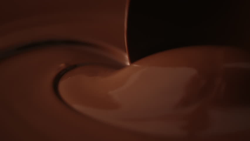Close-up stirring melted chocolate with pastry spoon, hot liquid chocolate in bowl, mixing molten milk chocolate fondue. Cooking handmade chocolate bars, dessert or candies. Confectionery slow motion | Shutterstock HD Video #1111457803