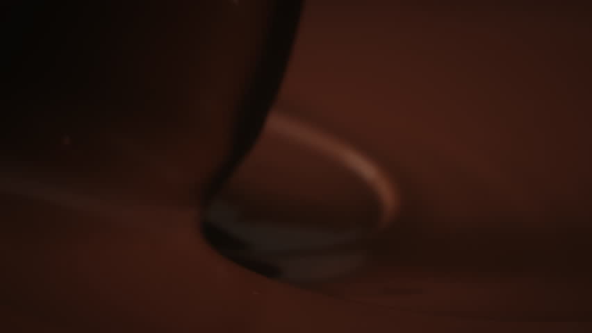 Close-up stirring melted chocolate with pastry spoon, hot liquid chocolate in bowl, mixing molten milk chocolate fondue. Cooking handmade chocolate bars, dessert or candies. Confectionery slow motion | Shutterstock HD Video #1111457811