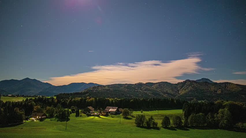 Nighttime time lapse with a bright moon and stars over Austria