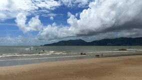 Sunny day at the beach. People riding jet skis in the surf. Patong beach, Phuket, Thailand.