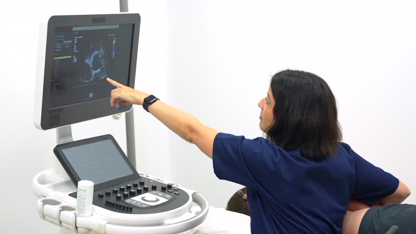 Female cardiologist doctor performing an echocardiogram on a patient in the hospital