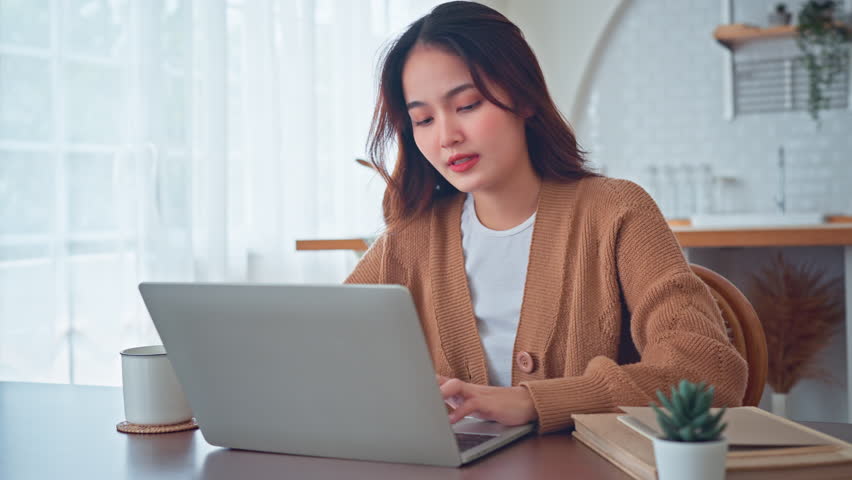 Excited young asian woman winner looks at laptop celebrates online work at home on desk with successful. Reads good news in email, Achieve target project. Royalty-Free Stock Footage #1111471663