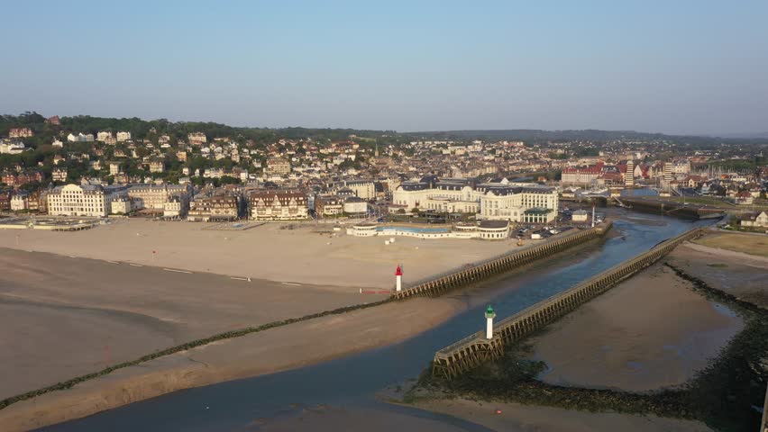 France, Trouville-sur-Mer, drone aerial view above the Trouville beach with the harbour entrance, close to Deauville. At sunset at low tide Royalty-Free Stock Footage #1111473527
