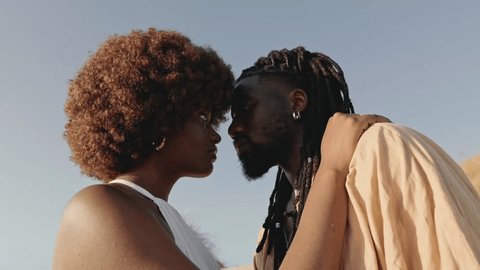 Closeup of a young African couple, deeply in love, embracing with intense eye contact, creating a moment of romantic connection: stockvideo