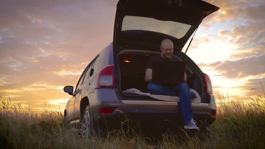 Tired adult man hate workforce life hybrid digital work anywhere turn off close logout laptop after end hard job done, sitting in car trunk while traveling, general plan in field at sunset. Busy | Shutterstock HD Video #1111480441