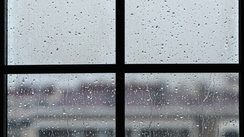 The Rain Drops Flowing on Window Glass
