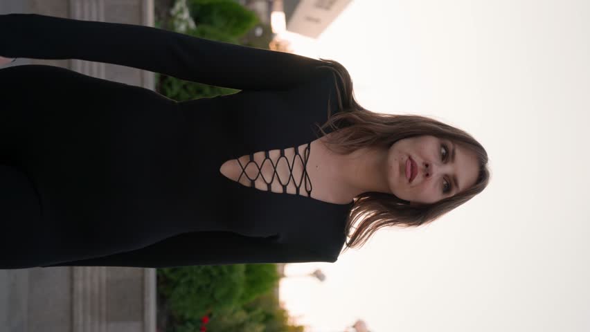 Seductive Slim Woman in a Black Tight Outfit Walks with a Confident Gait along a City Street. Fashion and Beauty Concept.Vertical Video, Slow Motion. | Shutterstock HD Video #1111488887