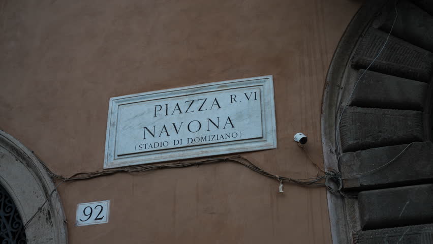 Close-up of Piazza Navona street sign on main street of Rome on facade of historic italian building. Concept of vacations and travel in Europe. Typical marble plaque, which indicates name of street. | Shutterstock HD Video #1111491005